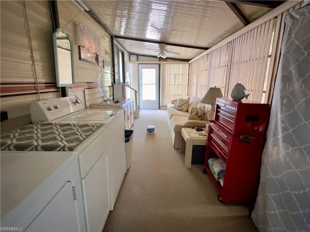 Kitchen featuring white cabinetry, a ceiling fan, washing machine and dryer, and light carpet
