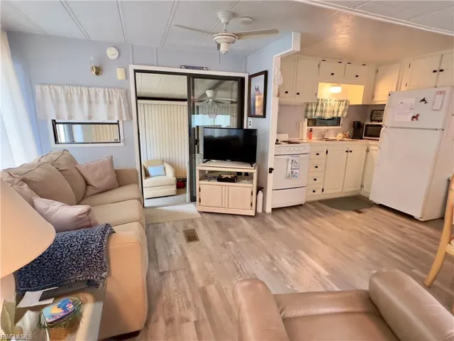 Living area with light wood finished floors and ceiling fan