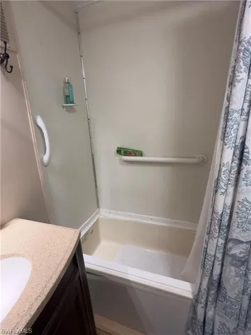Full bath featuring vanity and shower / tub combo with curtain