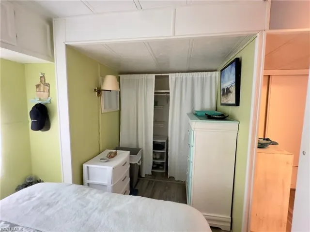Bedroom featuring dark wood-style floors and a closet