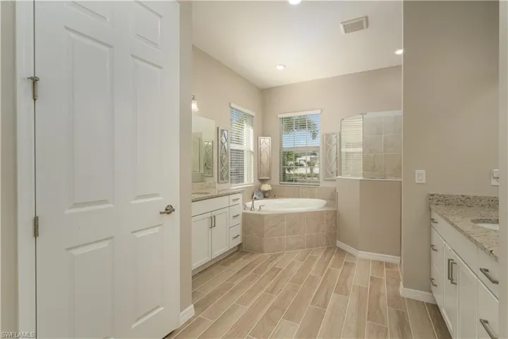 Primary bedroom with dual vanities, soaking tub and separate shower.