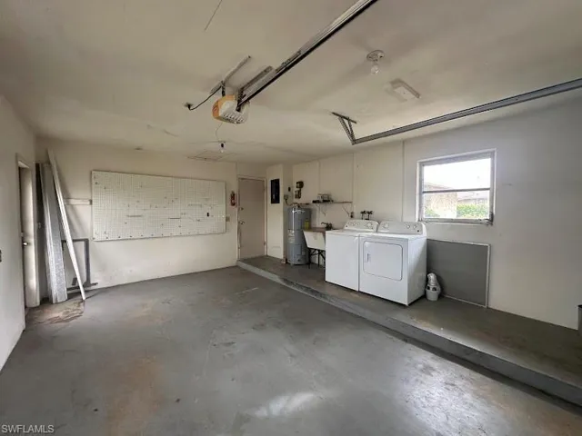 Garage with electric water heater, washer and clothes dryer, and a garage door opener