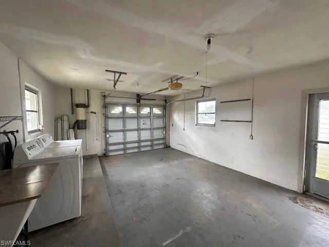 Garage featuring washing machine and clothes dryer and a garage door opener