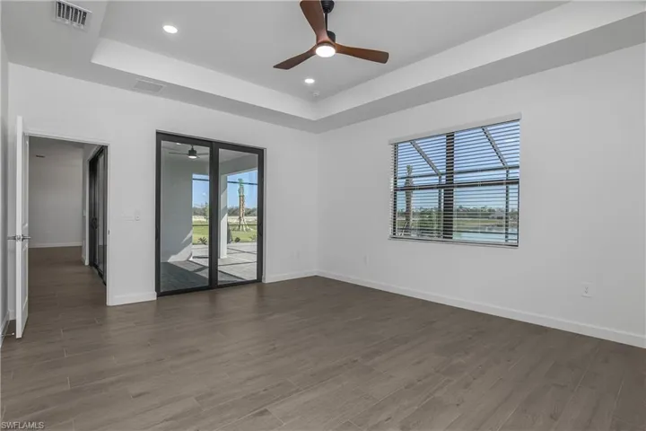 Primary bedroom with private lanai slider, upgraded recessed lighting, ceiling fan and fabulous water views.