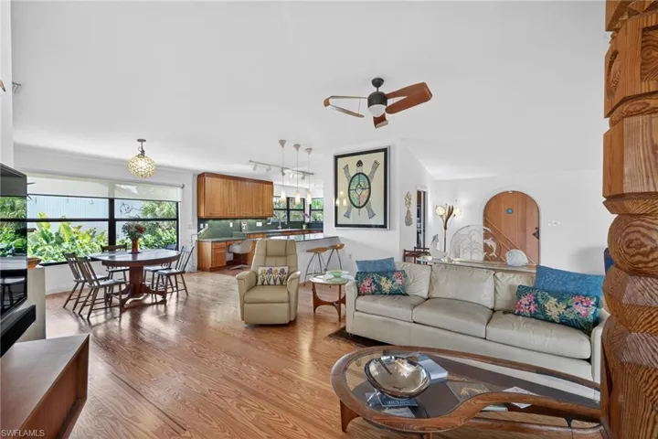 Living area with light wood-style flooring, ceiling fan, and rail lighting