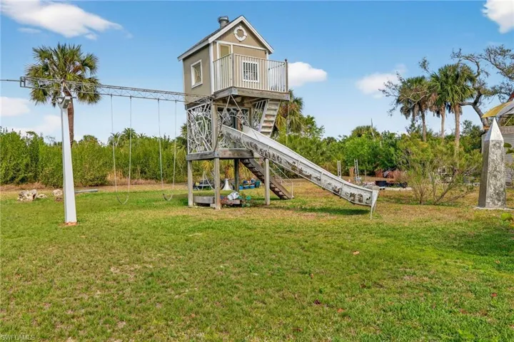 View of jungle gym with stairway and a yard