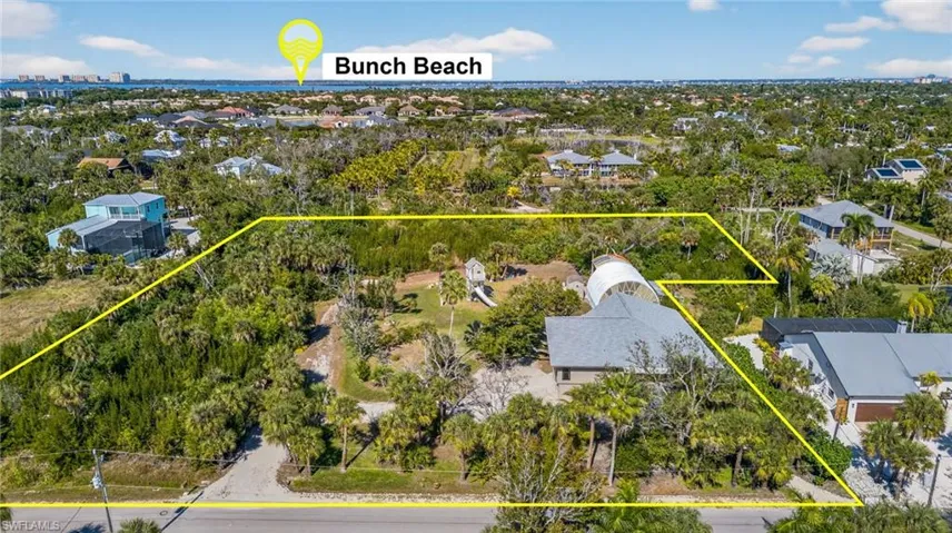 Aerial perspective of suburban area with property boundaries highlighted and a tree filled landscape