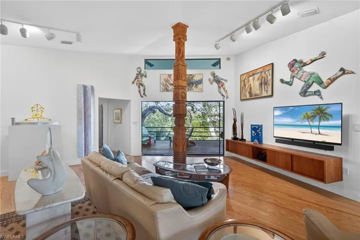Living area featuring rail lighting and wood finished floors