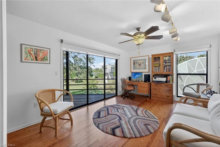 Office space featuring rail lighting, light wood-style floors, and a ceiling fan