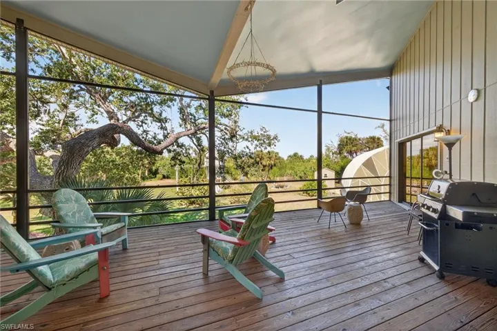 Sunroom with hanging lights and a deck