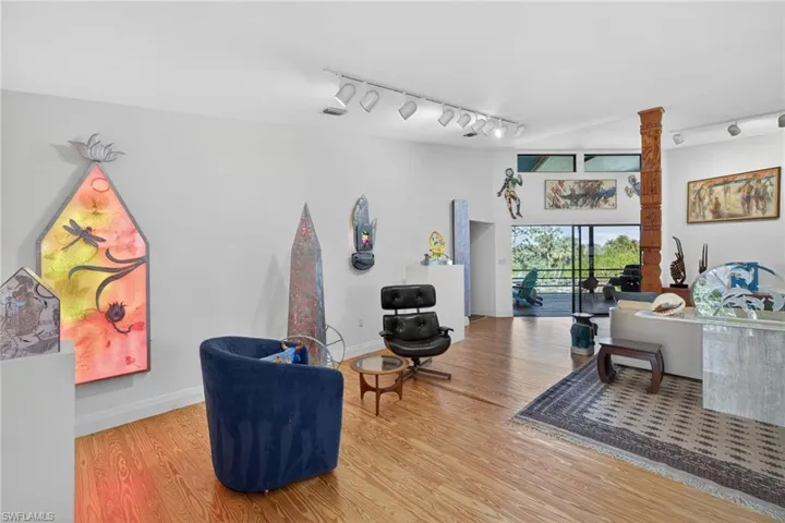 Living area featuring rail lighting and light wood-type flooring