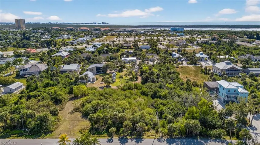 Aerial view of property and surrounding area featuring nearby suburban area