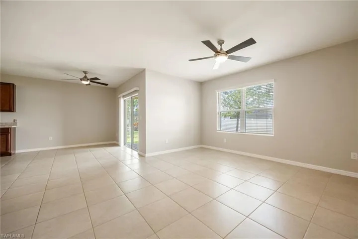 Unfurnished room with light tile patterned floors, baseboards, and a ceiling fan