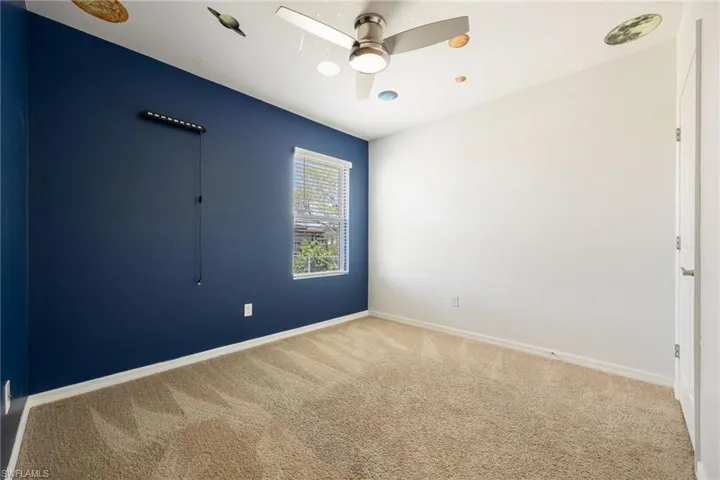 Unfurnished room with carpet flooring, baseboards, and a ceiling fan