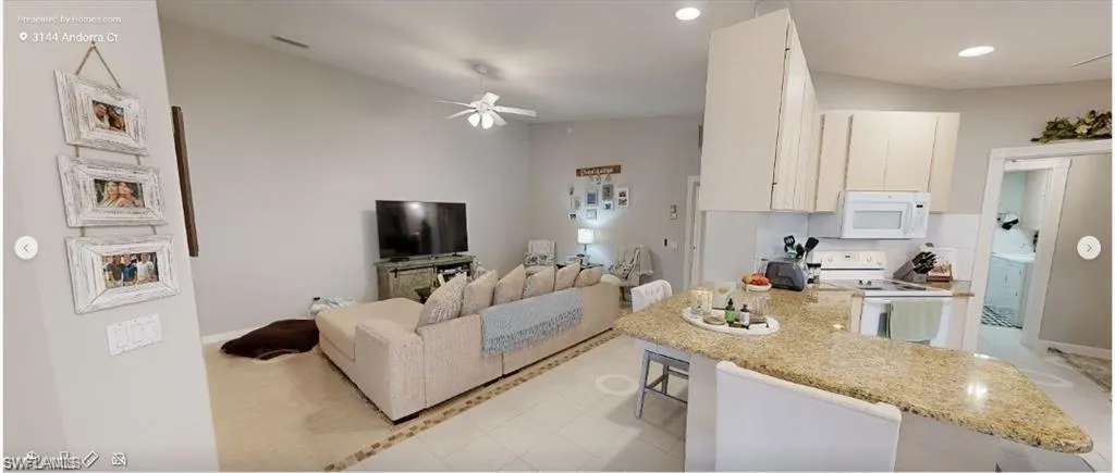 Living room with a ceiling fan, recessed lighting, and light tile patterned floors