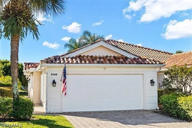 View of front of property with decorative driveway, an attached garage, stucco siding, and a tiled roof