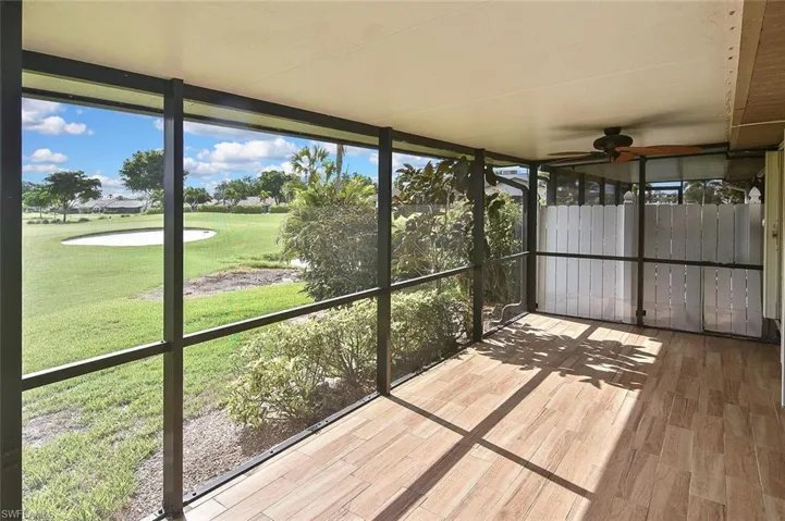 Unfurnished sunroom featuring ceiling fan, healthy amount of natural light, and view of golf course
