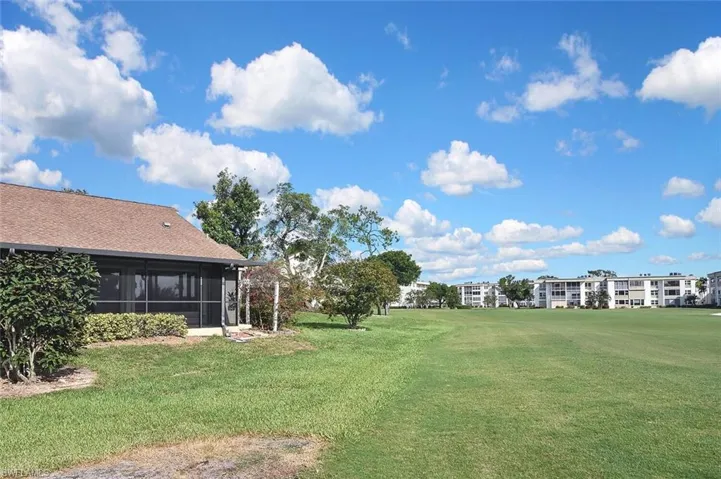 View of green lawn with a sunroom