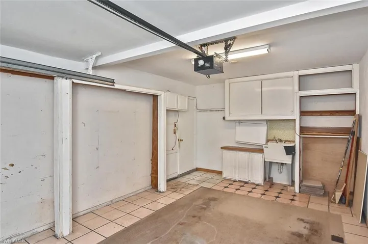 Garage featuring a garage door opener and a sink