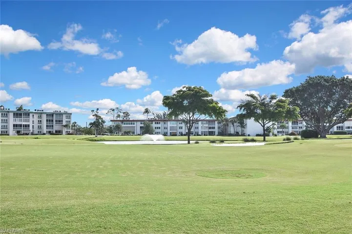 View of home's community with golf course view and a yard