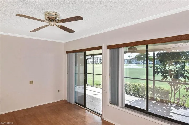 Spare room with wood finished floors, a textured ceiling, ceiling fan, and ornamental molding