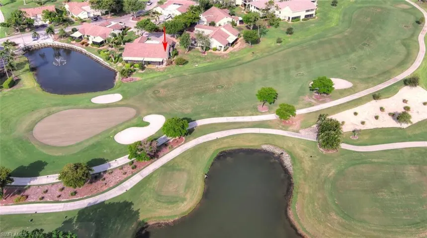Aerial view of property's location featuring a large body of water, a local golf course, and nearby suburban area