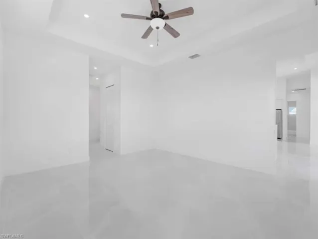 Spare room featuring recessed lighting, ceiling fan, and a tray ceiling