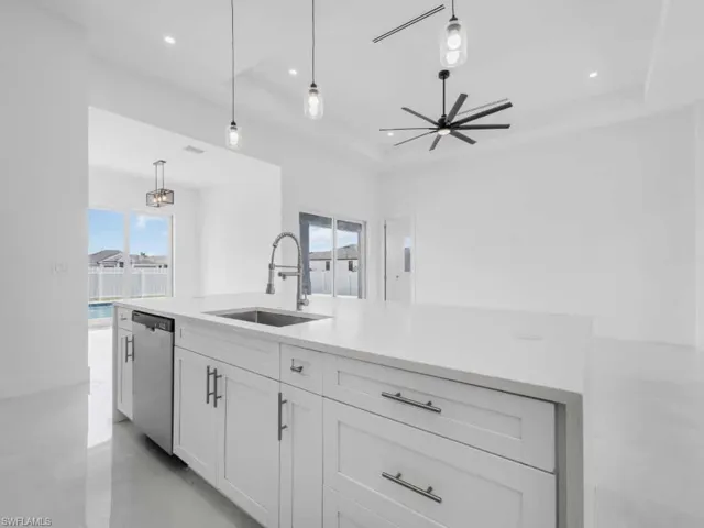 Kitchen featuring white cabinets, ceiling fan, decorative light fixtures, light countertops, and dishwasher