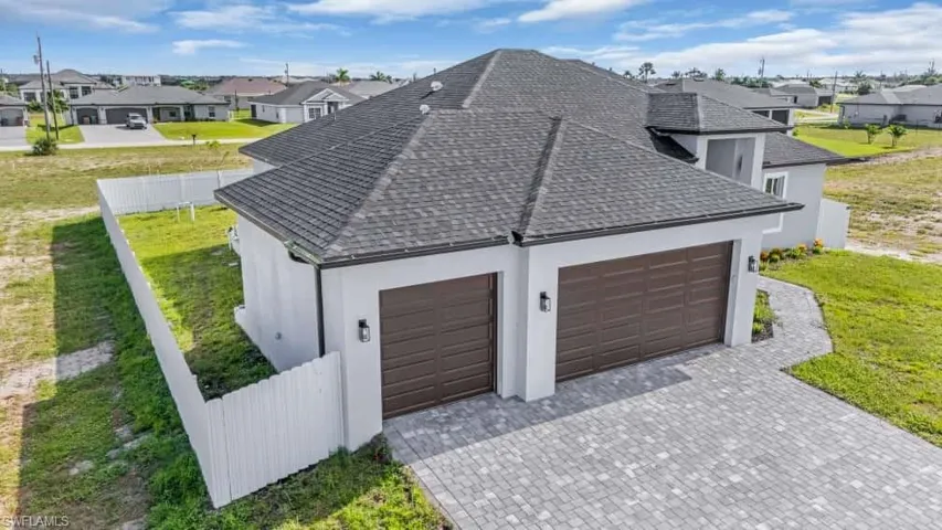 Garage featuring a residential view and decorative driveway