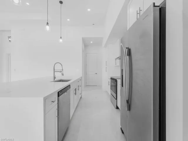 Kitchen with stainless steel appliances, white cabinetry, light countertops, recessed lighting, and decorative light fixtures
