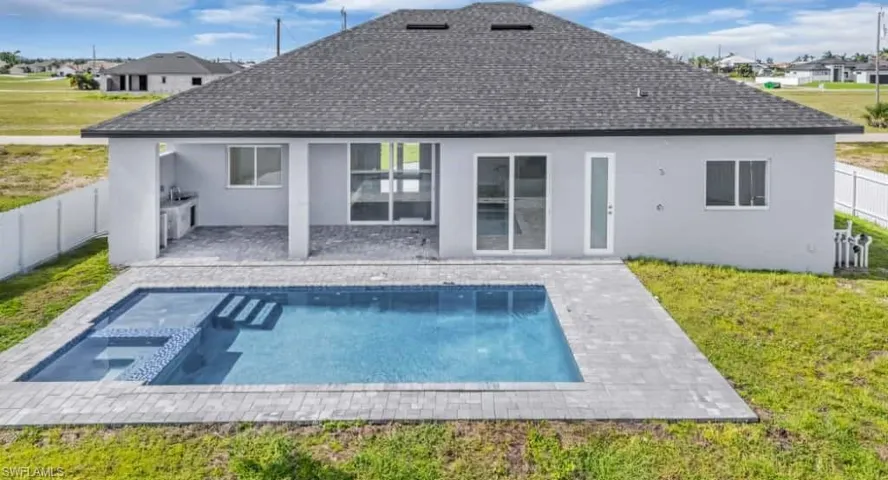 Rear view of property with a patio area, stucco siding, a jacuzzi, and a residential view