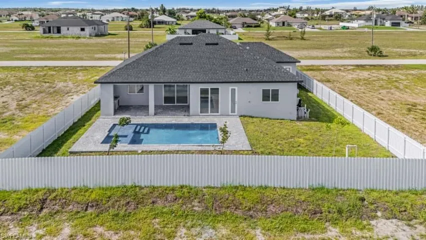 Rear view of house with a residential view, stucco siding, a fenced backyard, and a patio area