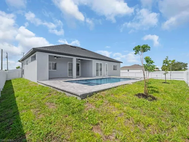Rear view of house with a ceiling fan, a fenced backyard, stucco siding, and a patio area
