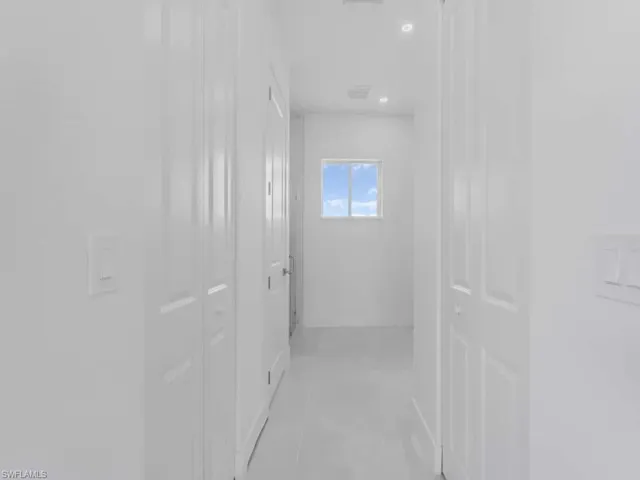 Hall featuring light tile patterned floors and recessed lighting