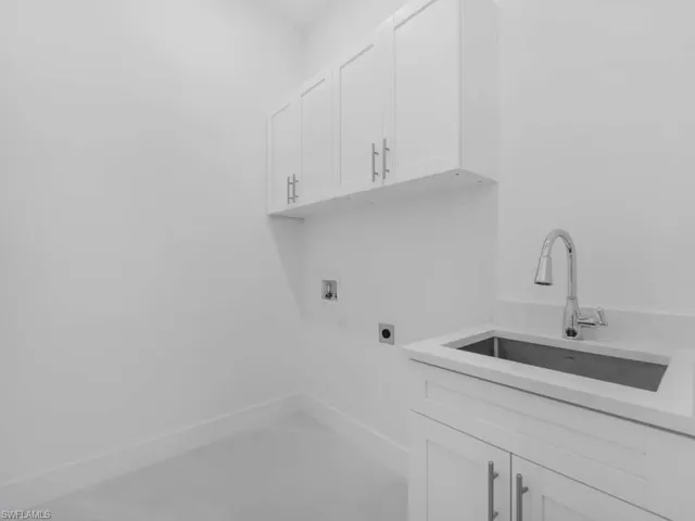 Laundry room with hookup for an electric dryer, hookup for a washing machine, and cabinet space