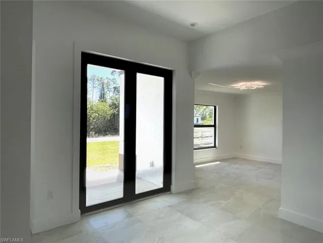 Entryway featuring baseboards and french doors