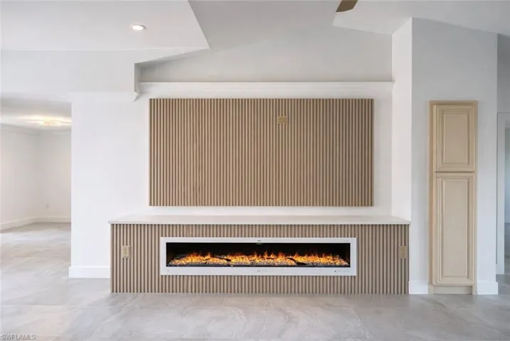 Detailed view of a lit fireplace and ceiling fan