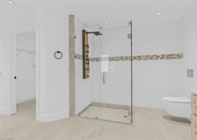 Full bath with vanity, a shower stall, recessed lighting, a walk in closet, and light tile patterned flooring