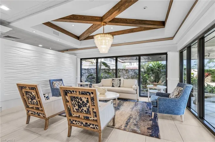 Living room with visible vents, coffered ceiling, and beamed ceiling