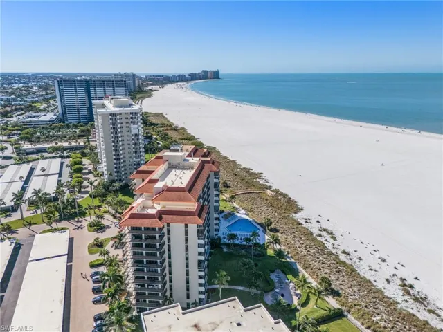 Drone / aerial view featuring a beach view, a water view, and a view of city