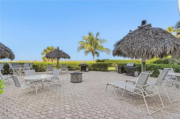 View of patio with area for grilling and a fire pit