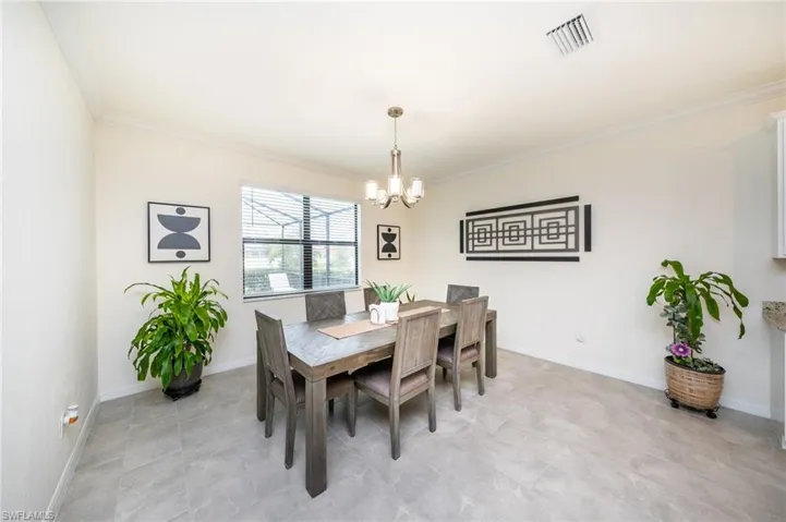 Dining area featuring crown molding and a chandelier