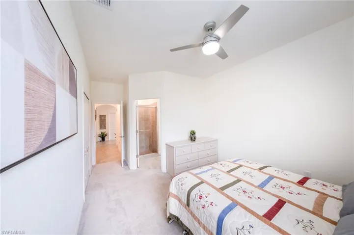 Guest Bedroom #2 featuring connected bathroom, ceiling fan, and light colored carpet