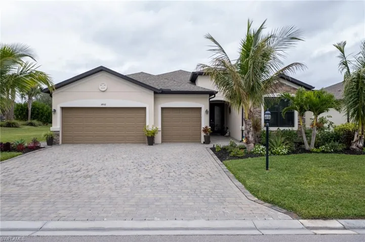 View of front facade featuring a front lawn and a garage