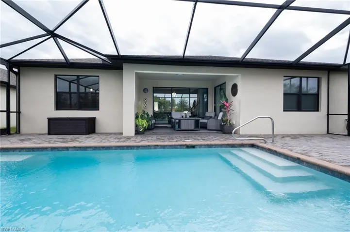 View of pool with a lanai, a patio area, and an outdoor living space