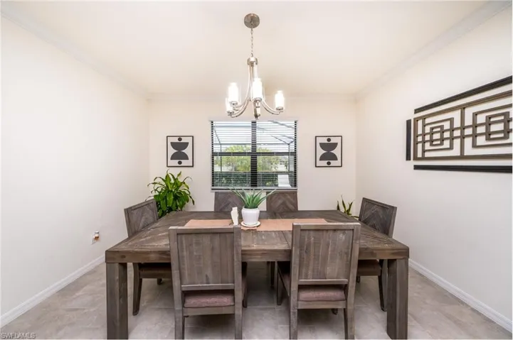 Dining area with ornamental molding and a notable chandelier