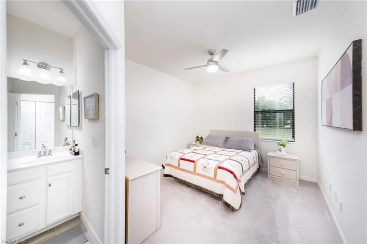 Guest Bedroom #2 with En-Suite Bath featuring ceiling fan, and light colored carpet