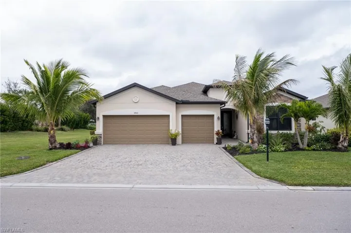 View of front of home with a beautiful lawn and a 3-car garage