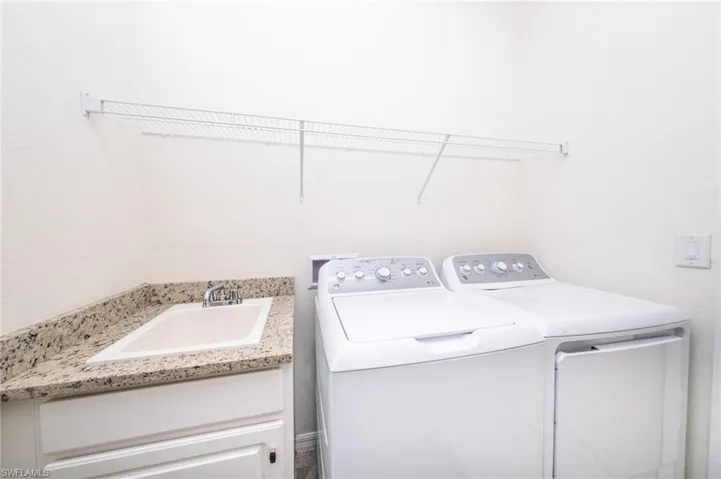 Laundry area featuring separate washer and dryer and sink