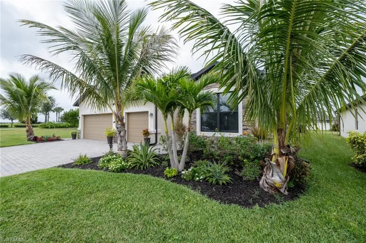 View of front of home featuring a beautifully landscaped lawn and a 3-car garage